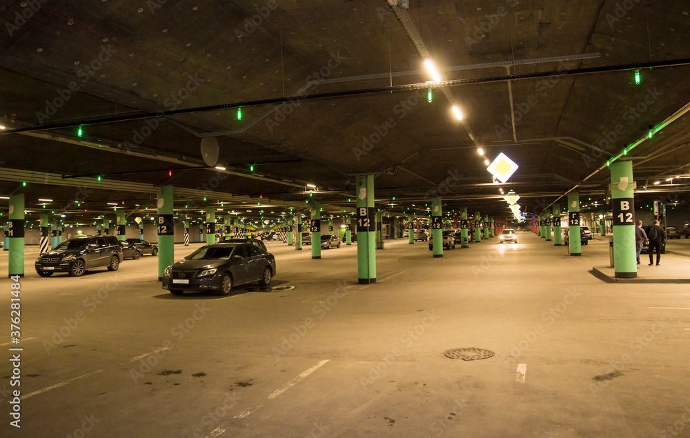 Underground parking in a large shopping mall. Car spaces are marked ...