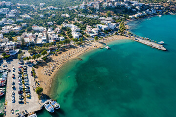 Wall Mural - ELOUNDA, CRETE, GREECE - 27 AUGUST 2020: Aerial view of the public beach in the popular Greek tourist town of Elounda on the island of Crete