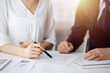 © rogerphoto - Unknown businessman and woman discussing contract in sunny office, close-up.Business people or lawyers working together at meeting