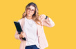 Young caucasian woman wearing business clothes and glasses holding binder with angry face, negative sign showing dislike with thumbs down, rejection concept