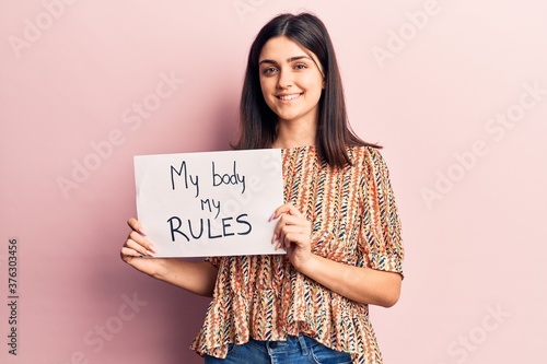 Cuadros en Lienzo Young beautiful girl holding my body my rules banner looking positive and happy