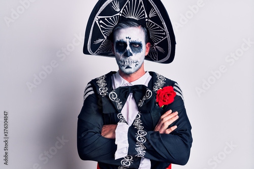 Cuadros en Lienzo Young man wearing mexican day of the dead costume over white skeptic and nervous, disapproving expression on face with crossed arms