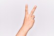 © Krakenimages.com - Close up of hand of young caucasian man over isolated background counting number 2 showing two fingers, gesturing victory and winner symbol