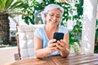 © Krakenimages.com - Middle age woman with grey hair smiling happy relaxing sitting at the terrace at home using smartphone