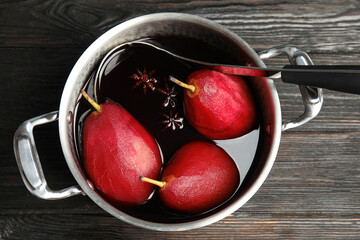 poaching pears in mulled wine on wooden table, top view