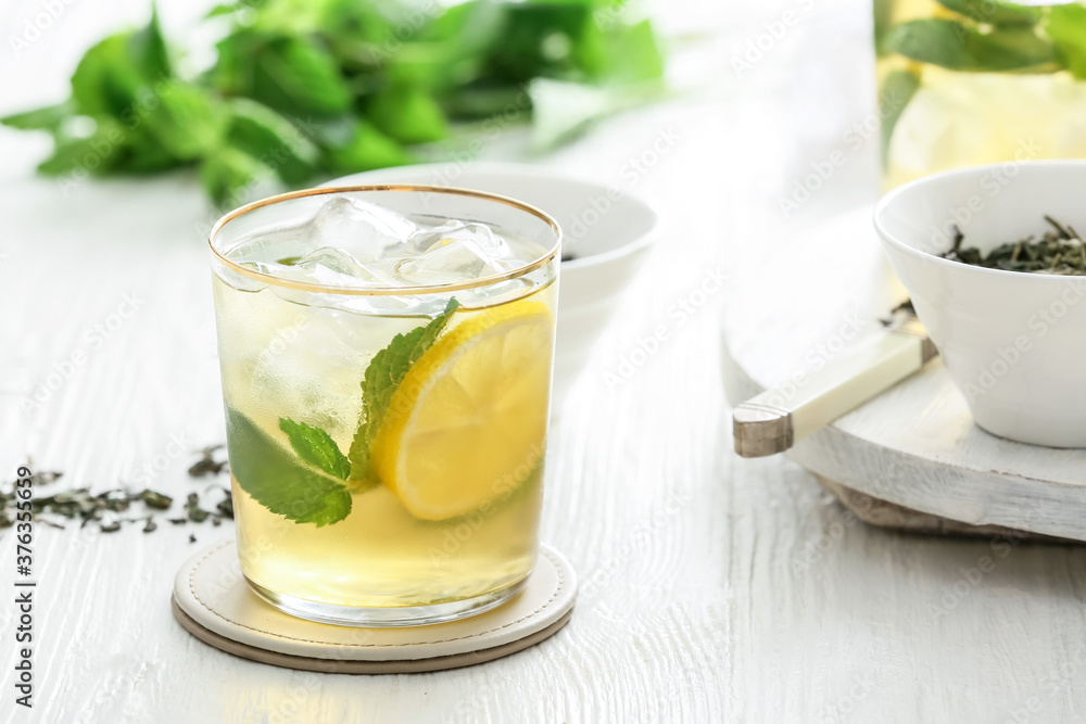 Glass of tasty cold ice tea on table