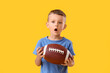 © Pixel-Shot - Surprised little boy with rugby ball on color background