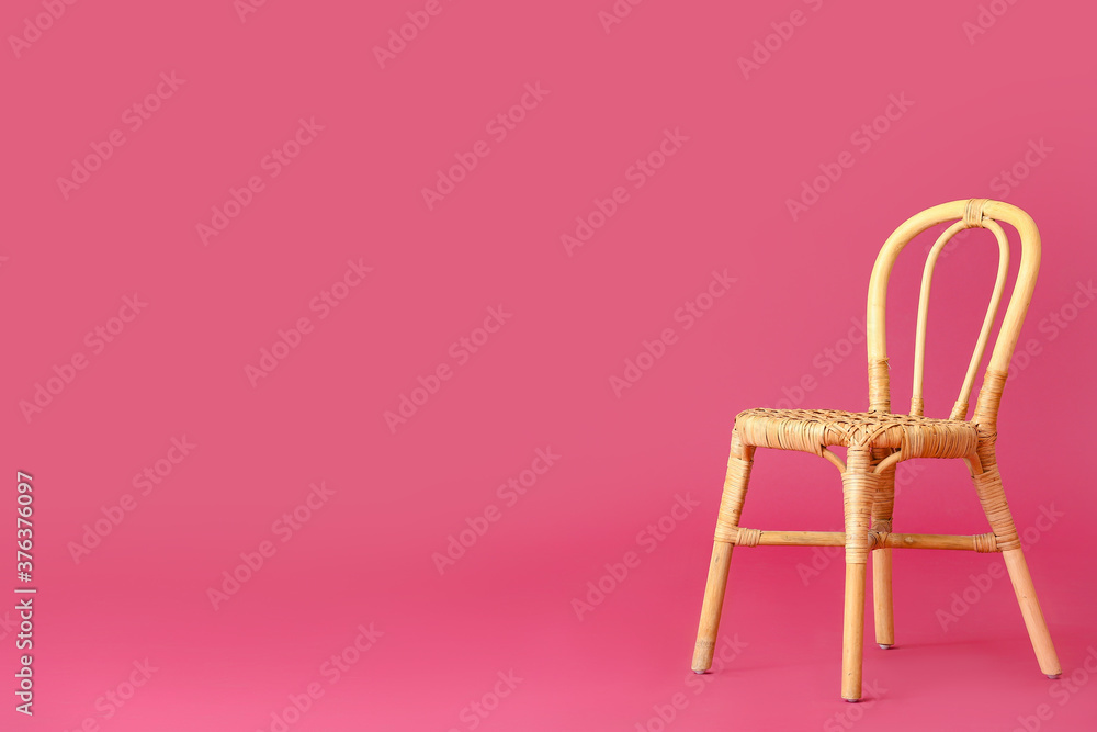 Wicker chair on color background