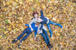 © somemeans - Mother and two sons lying on autumn foliage in forest. Young family in Park. Top view.