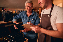 Two Men Working Together In Winery Cellar