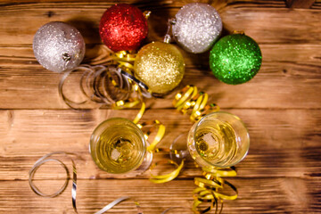 Wall Mural - Two wineglasses with champagne and different christmas decorations on wooden table. Top view