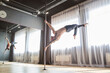Man athlete performing exercises on the pole on the stage