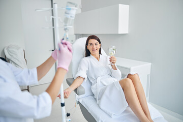 Wall Mural - Woman enjoying the intravenous therapy in a beauty salon