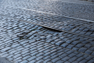 Broken pavements sidewalks on the sidewalk. pavement with paving slabs with defects and cracks going in perspective. The road from the stone, which begins to sink, and created a depression