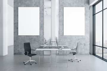 Modern coworking office interior with two empty posters on gray wall.