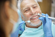 Mirthful senior citizen smiling during a dental treatment