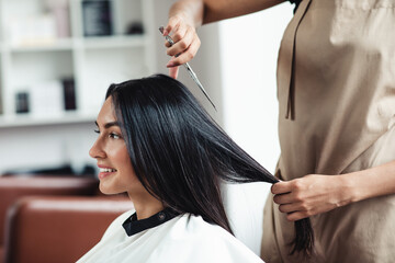 Wall Mural - Young brunette woman getting short haircut at hairdressers, close up