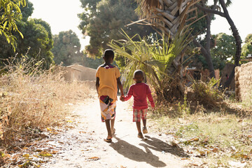 Two African Children Walk Down Natural Road in African Village