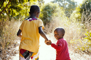 Smiling African Children Walking Outdoors in Typical Tribal Town Near Bamako, Mali (Africa)