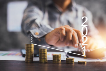 low and down business in 2021, businessman pointing on arrow graph on stacked of coins, business impact Loss performance, save and financial earning concept