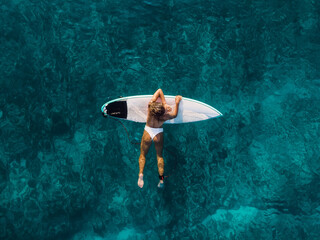 Wall Mural - Attractive surfer woman on surfboard in ocean. Aerial view