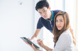 © themorningglory - Asian young businessman and businesswoman using tablet at office meeting
