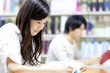 © Paylessimages - 図書室で勉強する女子大学生