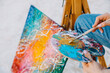 © Bostan Natalia - Closeup of a woman artist painting with a paintbrush, holding a palette.