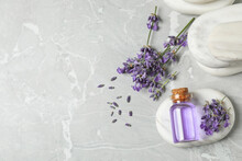 Stones, Bottle Of Essential Oil And Lavender Flowers On Marble Table, Flat Lay. Space For Text