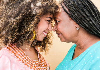 Beautiful african mother and daughter with forehead together - Happy family love 