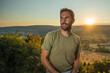 © Anze - A young casual caucasian male with beard and green shirt is posing in the evening hours with the sun just about to set over the french countryside.
