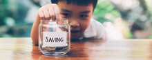 Happy Asian Children Saving Money Putting Coin In Glass For Wealth And Growth Of Earning, Finance And Investment For Success, Boy Planning And Deposit, Business And Economy Concept, Banner Website.
