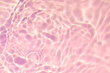 Closeup Of Pink Transparent Clear Calm Water Surface Texture With Splashes And Bubbles. Trendy Abstract Summer Nature Background. Coral Colored Waves In Sunlight. Copy Space.