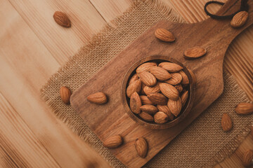 Wall Mural - AlmondsAlmonds In Bowl on wood table background with copy space.top view. In Bowl on wood table background with copy space.