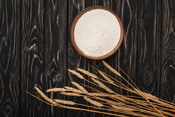 Sticker - top view of spikelets and flour in bowl on wooden surface