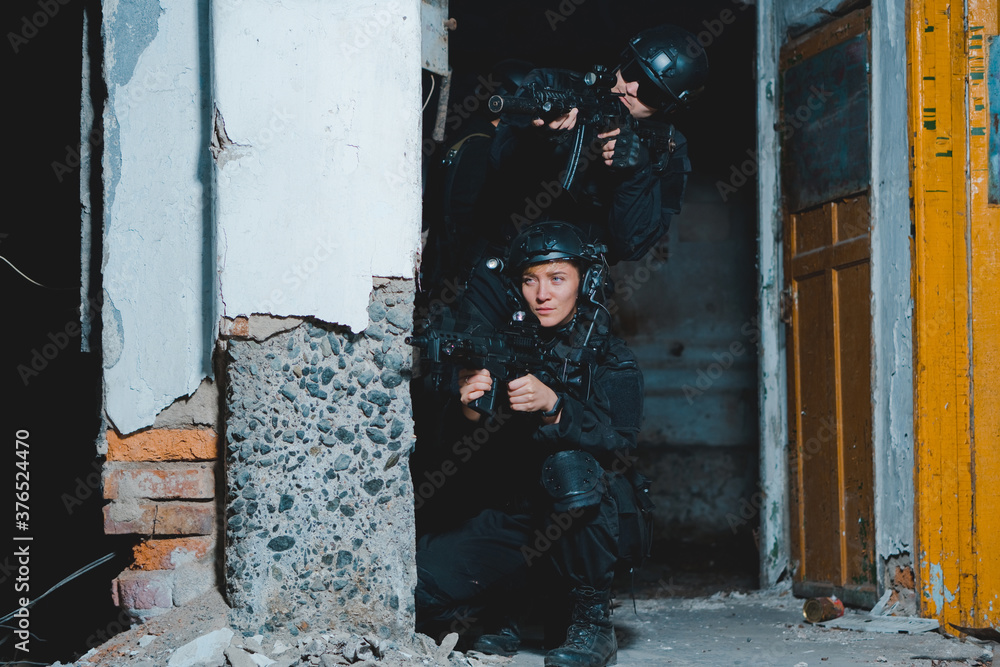 Special forces woman soldier in black uniform aiming with a rifle Stock ...