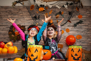 children in halloween costumes play with candy
