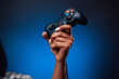 Pretty hands of afro woman grips the modern gaming joystick and lifting it up. Youth modern hobby and sport platform.