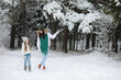 © alexkich - Young family for a walk. Mom and daughter are walking in a winter park.