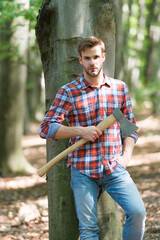 Wall Mural - lumberjack worker man standing in the forest with axe, summer
