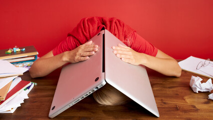 portrait of a young caucasian woman holding laptop computer on his head, deadline at work, frustration concept, being fired from job dismissed at work due to economic crisis and recession