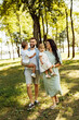 © shunevich - Loving parents with little kids walking at the park, adorable mother hold in arms beautiful daughter, cute son sitting in fathers hands, enjoy happy family weekend concept