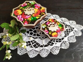 Items of Russian traditional national craft lace napkin wooden boxes tray with painting white berries on a twig