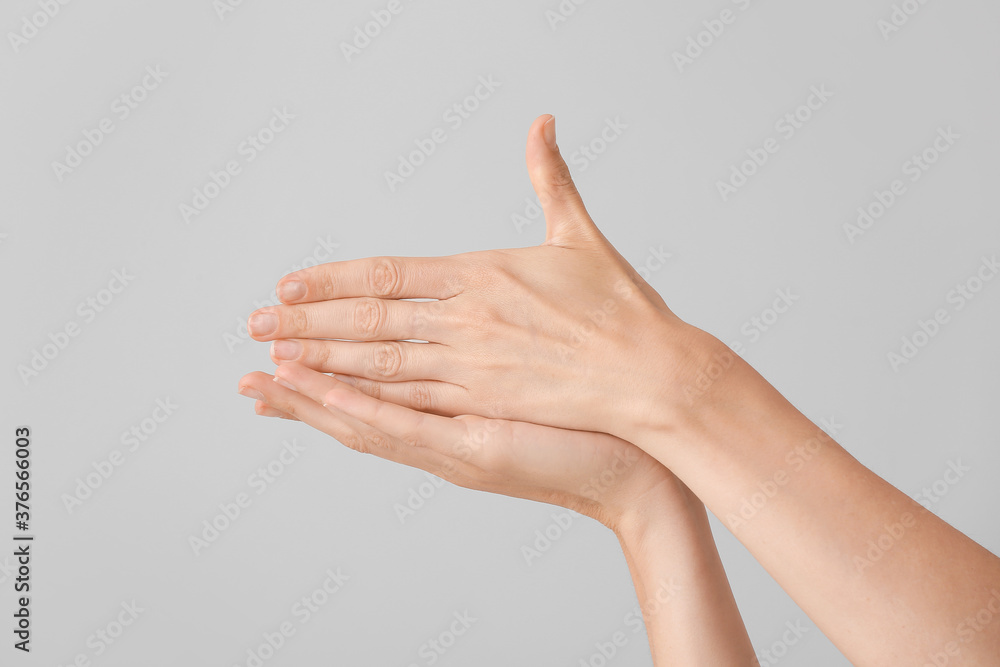 Young deaf mute woman showing sign STOP on grey background