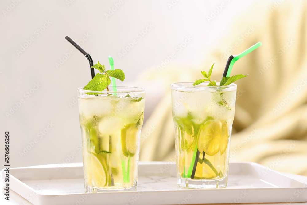 Glasses of tasty cold ice tea on table in room