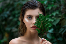 Beautiful Young Woman With Perfect Skin And Natural Make Up Posing Front Of Plant Tropical Green Leaves Background. Teen Model With Wet Hair.  SPA And Skincare.