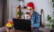 © Artem - Modern man is working on a laptop, and his little son is sitting on his lap. Concept of family and remote work from home