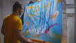 © DC Studio - Artist paints on large canvas with fingertips in art studio.