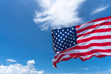 Wall Mural - Waving USA flag under blue sky background.