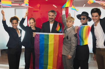 Group of business people with diverse genders (LGBT) celebrate LGBT freedom and support with LGBT flag in the meeting room at office workplace